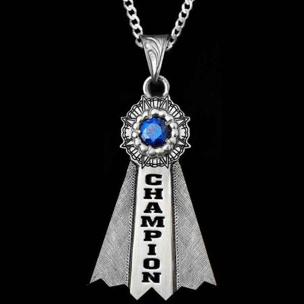 "Our stunning Champion Showman Pendant is a tribute to the pride and accomplishment of winning a blue ribbon. Crafted from high-quality German Silver, this pendant features our signature silk finish, beautiful ribbon details and a cubic zirconia ston